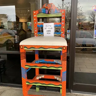 a colorful chair in front of a store