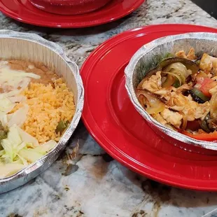 Chicken Fajitas with sides of rice, beans, lettuce and guacamole