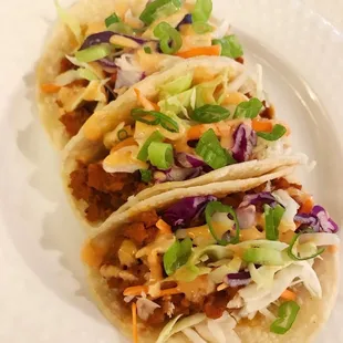 three tacos on a white plate