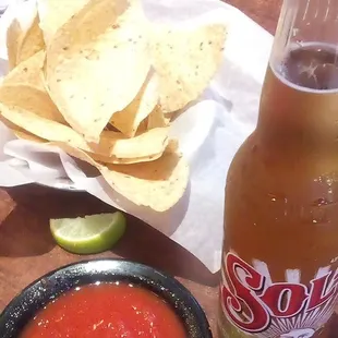 a plate of chips and a bottle of soda