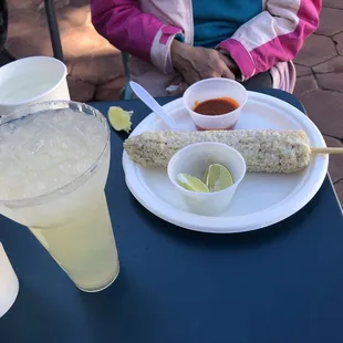 Lime margarita on the rocks and mexican style corn with hotsauce on the side.