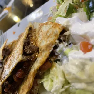 Sincronizada Quesadilla One large quesadilla with ham, grilled steak and cheese. Served with pico de gallo, lettuce and sour cream.