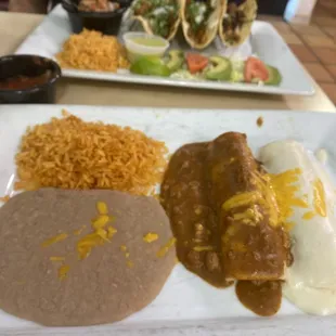 Beef enchilada with Chile con carne, chicken enchilada with sour cream sauce, beans and rice.