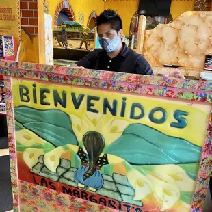 a man in a mask behind a sign