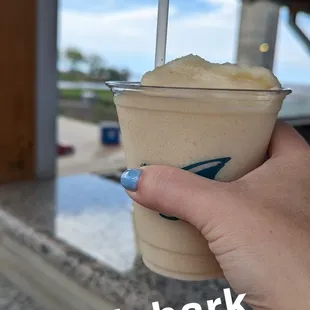 a hand holding a cup of ice cream