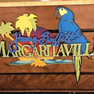 a parrot perched on a sign
