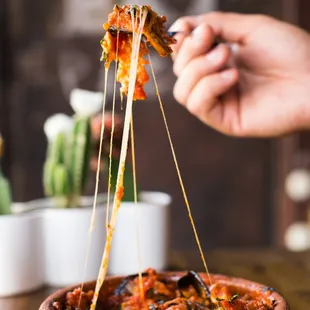 a hand holding a piece of margherita