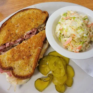 Reuben sandwich with side coleslaw and pickles