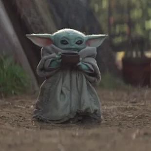 baby yoda drinking from a bowl