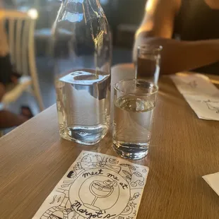 a glass of water and a bottle of water on a table