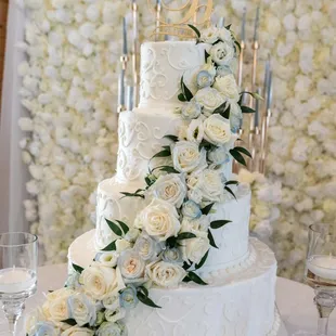 a wedding cake with white roses and greenery