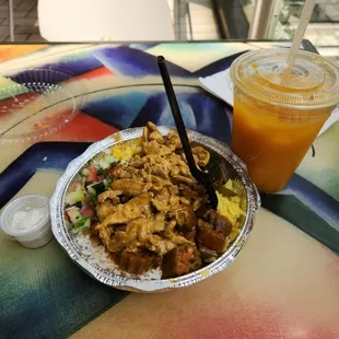 Half and half white rice and yellow rice, shawarma, okra, corn, veggies, side of garlic sauce, and mango drink with ice.