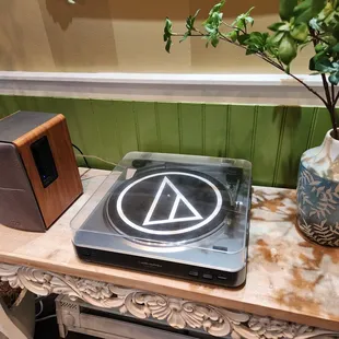 a record player and a vase on a table