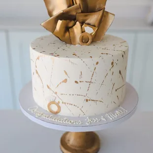 a white cake with a gold bow on top