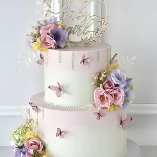 a three tier cake decorated with flowers and butterflies