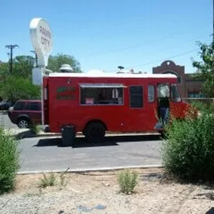 a red food truck parked in a parking lot