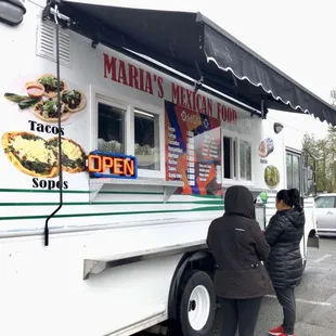 two people ordering food from a food truck