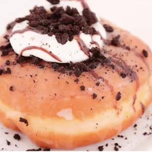 a donut with whipped cream and chocolate sprinkles