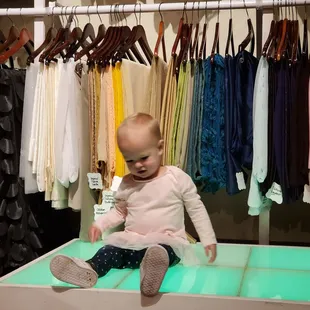 Everyone is welcome! This cutie is sitting in front of drape samples on our lit dance floor sample.