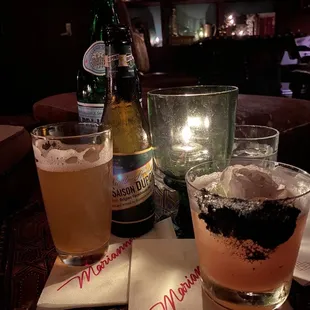 two glasses of wine and a bottle of beer