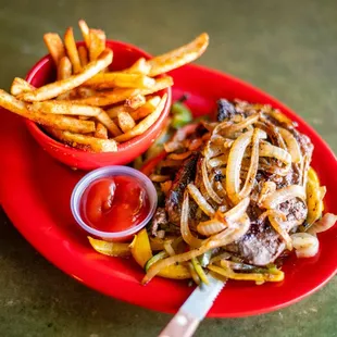 a plate of food with fries and a bowl of ketchup