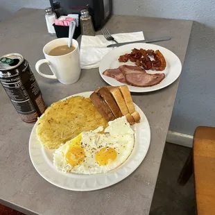 a breakfast of eggs, bacon, toast, and coffee