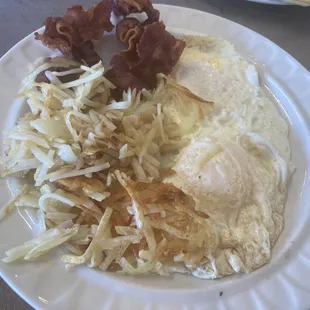 Eggs over medium, hash browns and perfectly cooked crispy bacon
