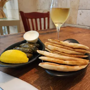 a plate of pita bread and a glass of wine