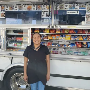 a woman standing in front of a food truck