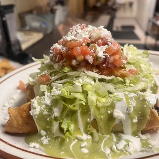 Smoked pork butt taquitos with sour cream, pico de Gallo, avocado sauce and cotija cheese.