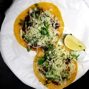 two tacos on a paper plate