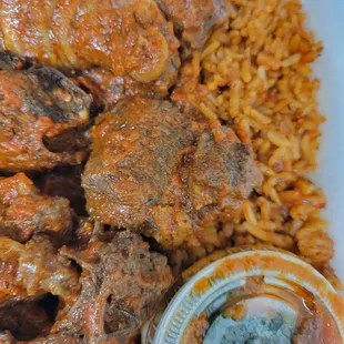 Jollof rice with meat and a side of spinach