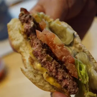 a hand holding a hamburger