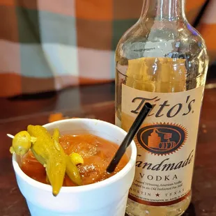 a bottle of liquor and a bowl of pickles