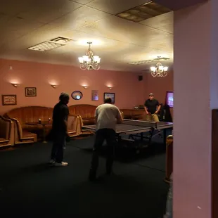 a group of people playing a game of table tennis