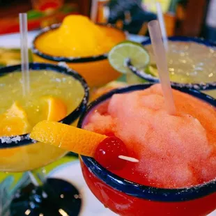 three margaritas with oranges and limes