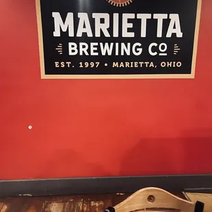 a wooden chair in front of a red wall