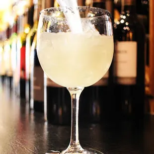 a person pouring a drink into a glass