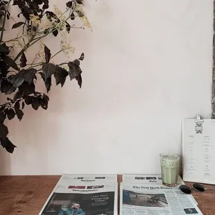 a table with a newspaper and a plant