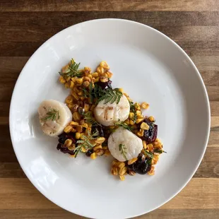 Seared scallops over roasted corn and cherry salad and marigold