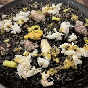 a pan of black rice with meat and vegetables