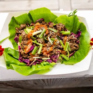 a plate of lettuce with meat and vegetables