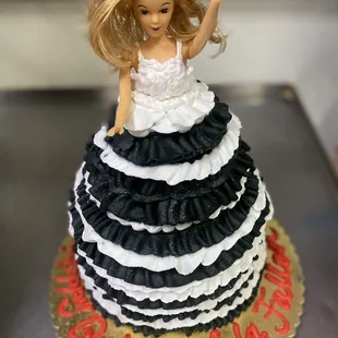 a barbie doll on top of a cake