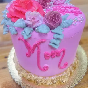 a pink and purple cake with flowers on top