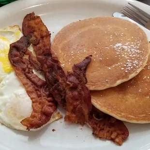 Two eggs over easy, choice of sausage or bacon, two pancakes