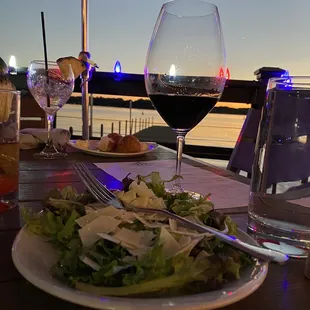 a plate of salad and a glass of wine