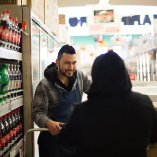 Grocer Mr. Valentin helping out a customer!