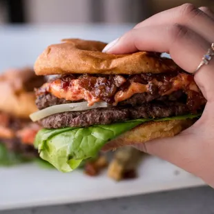 a hand holding a burger