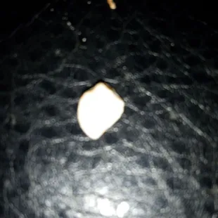 Piece of a pill or what looks to be a sweet tart?