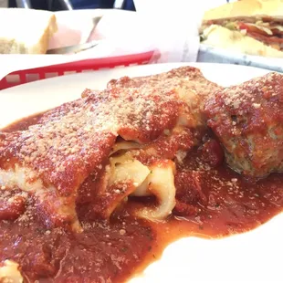 Cheese lasagna with a meatball.